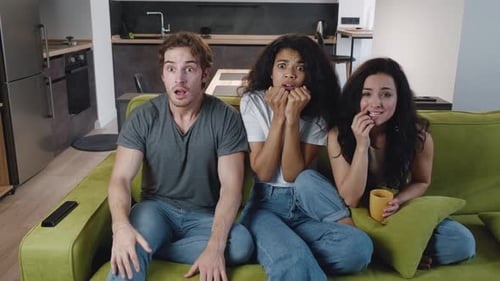 Friends react while watching sports on tv