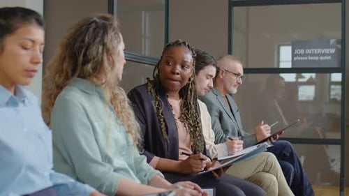 Femmes assises en ligne et discutant avant l'entretien d'embauche