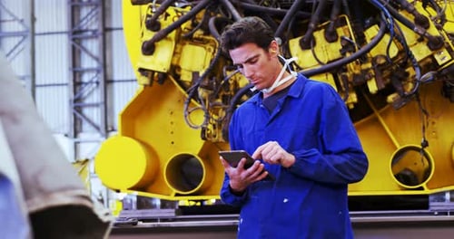 Factory Worker Using Tablet in Manufacturing Facility