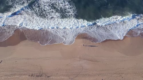 Aerial View of Man Seen Walking Along Shoreline