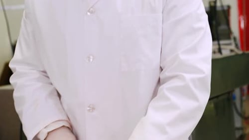 Adult Cuts Raw Meat in Industrial Setting