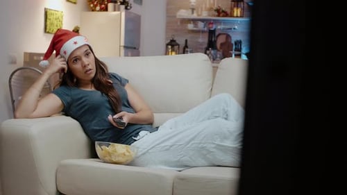 Woman Watching TV with Santa Hat On