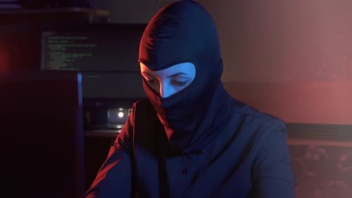 Masked Hacker Working on Computer at Night