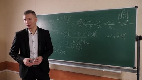 Portrait of a Male Math Teacher in College Near the Blackboard