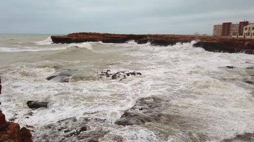 Giant Wave Crashing Onto Rocks As Frame Filled with Ocean Spray in Slow-motion