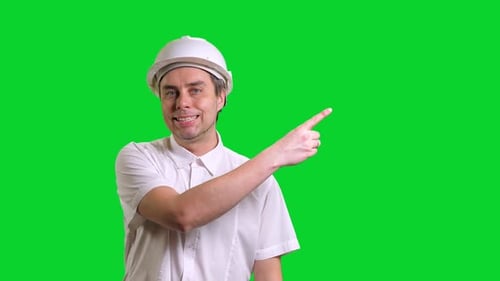 Young Male Engineer Standing and Pointing Aside on Green Screen Background
