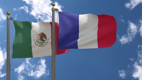 Mexican and French National Flags Waving Against Blue Sky