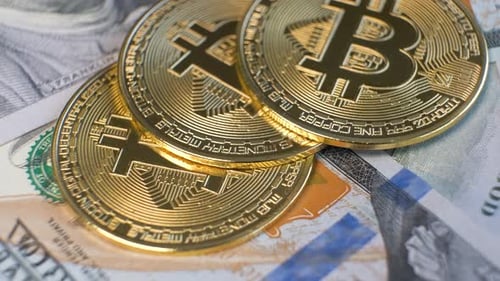 Close Up of Metal Shiny Bitcoin Crypto Currency Coins on US Dollar Bills
