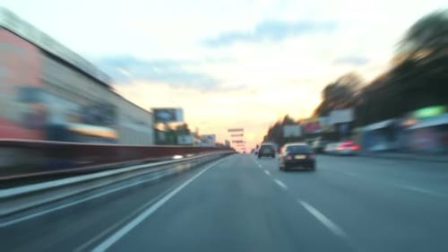 Fahrzeit in der Abenddämmerung durch die Stadt, Autos mit Lichtern