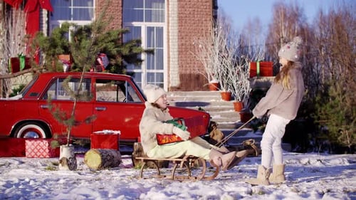 Girls Enjoying Winter Sledding with Christmas Gifts