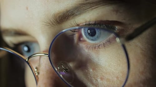 Closeup Eyes of a Teenage Girl with Glasses Looks at the Monitor Plays a Game Reads Studies