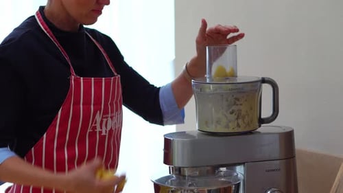 Frau benutzte elektrische Küchenmaschine, um Kartoffeln in der Küche zu hacken. - Nahaufnahme