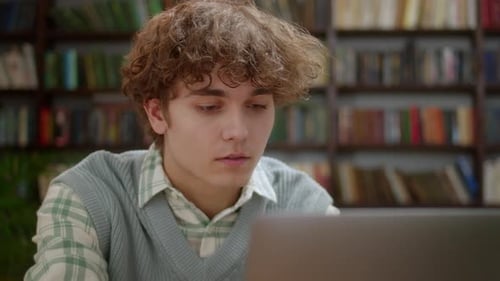 Student Using Laptop in Library Setting