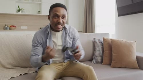 Enthusiastic Young Man Playing Video Game at Home