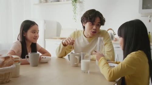 Siblings Enjoying Breakfast Together at Home