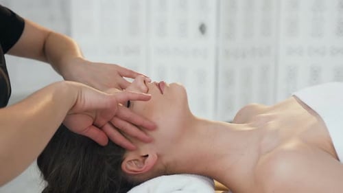 Woman Receiving Relaxing Facial Massage at Spa