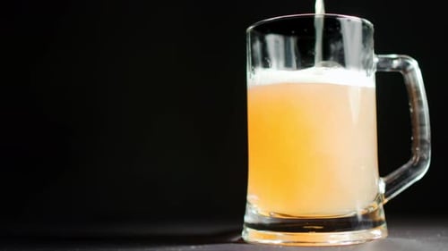 Pouring Beer into Clear Glass Mug