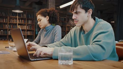 Young Couple of Diverse Ethnicities Work or Study at Library