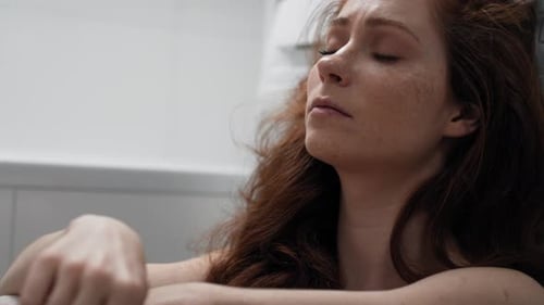 Woman Looks at Pregnancy Test in Bathroom