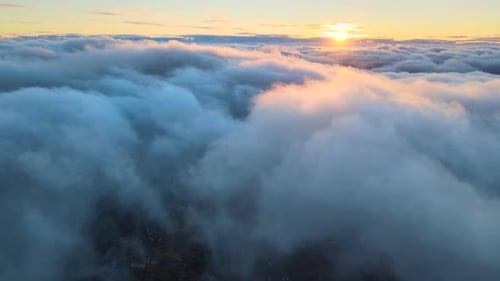 Aerial View From Above at High Altitude of Dense Puffy Cumulus Clouds Flying in Evening