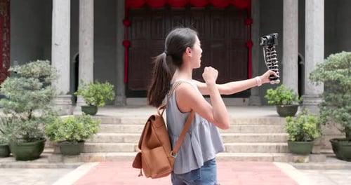 Woman taking video on camera in Chinese temple