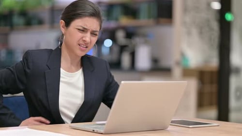 Tired Indian Businesswoman with Laptop Having Back Pain in Cafe
