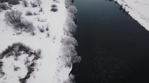 Fluss in Winterlandschaft mit schneebedeckter Küste
