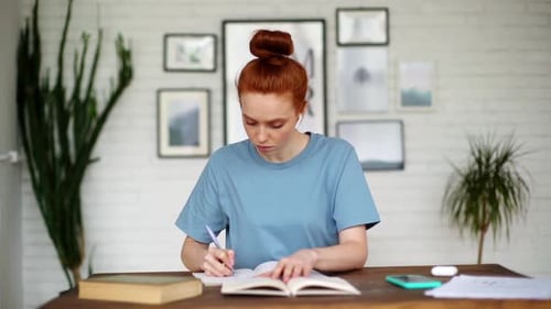 Young Woman Studying at Home, Writing in Notebook