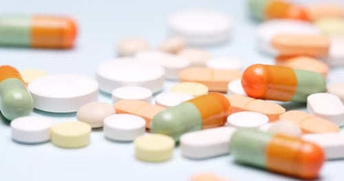 Pharmaceutical Pills scattered on a blue surface