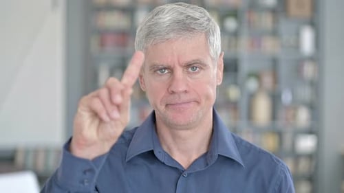 Mature Man Says No With Finger Gesture