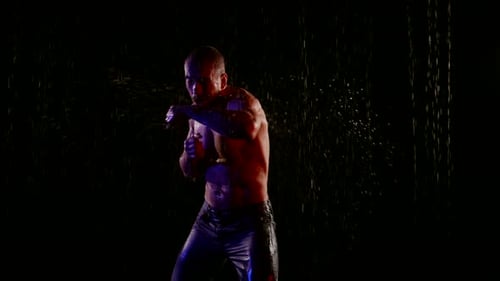 Muscular Man Boxing in the Rain at Night