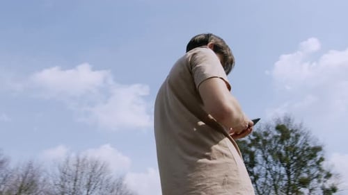 Young Adult Using Mobile Phone in Park