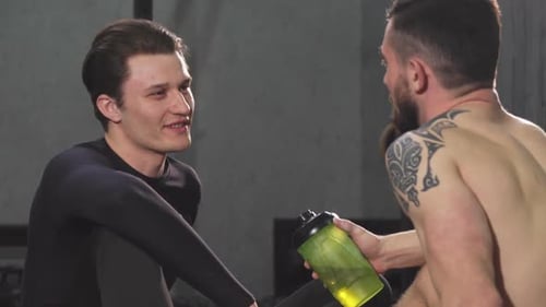 Young Male Athlete Talking To His Friend at the Gym