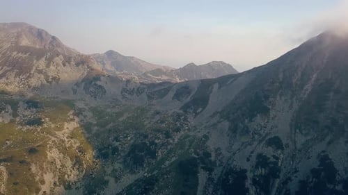 Large Drone aérien tombant lentement face à une chaîne de montagnes.