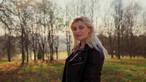 Beautiful female portrait looking at camera at autumn park outdoors. Attractive 30s caucasian woman