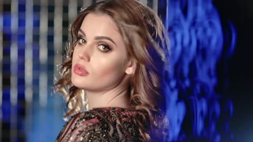 Closeup Portrait of Sexy Woman with Waving Hair at Studio with Blue Lights Neon Background