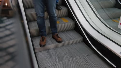 People on Stairs of Moving Escalator at Shopping Mall