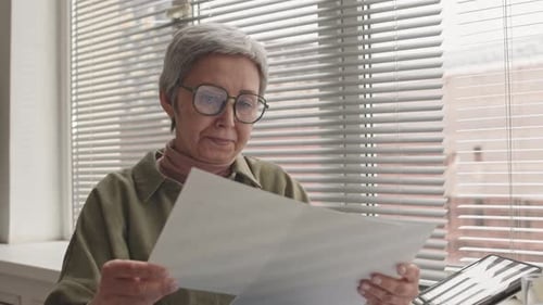 Woman Wearing Eyeglasses Reading Documents