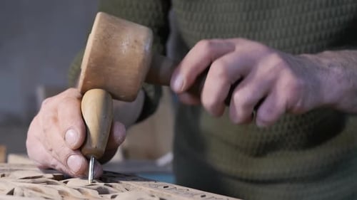 Adult Carving Intricate Wood Design with Chisel
