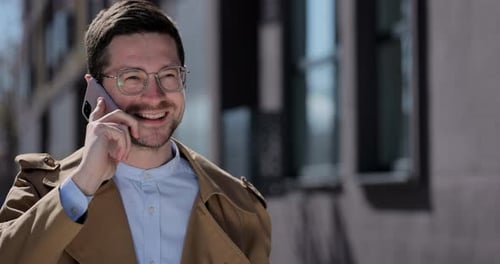 Portrait Handsome Man in Glasses Having Phone Talk on the Street