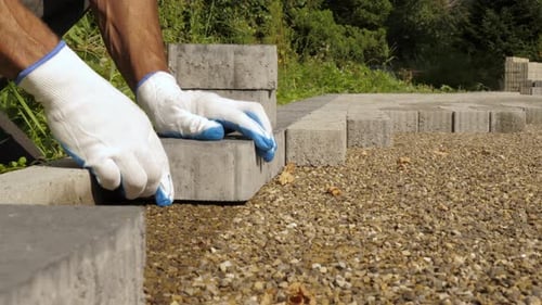 Builder Laying Pavement Rocks on the Street