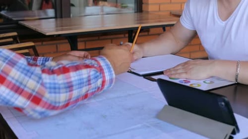 Ein Treffen von zwei Bauingenieuren, um die Konstruktionszeichnungen eines Business Centers zu besprechen.