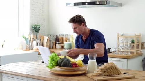 Man Working on Laptop in Bright Kitchen