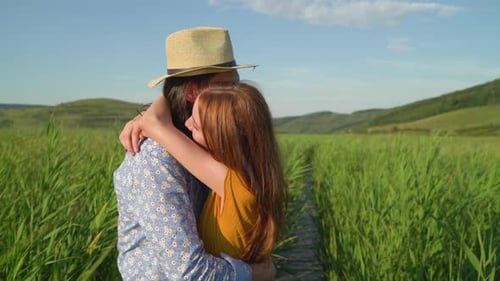 Affectionate Couple Embracing in a Grassy Field