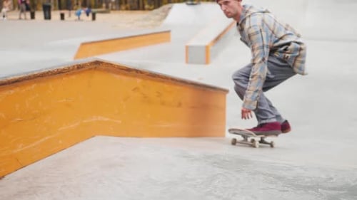Skater Practicing in the Autumn Concrete Skate Park Making Tricks and Rides in Ramp