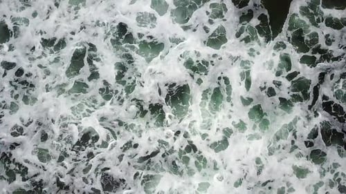 View of wave crashing on beach from above