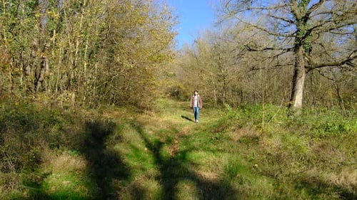 Teenage Boy Walking on Forest Path in Autumn