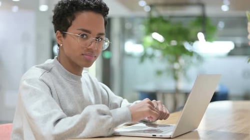 Young Woman Working on Laptop in Modern Office