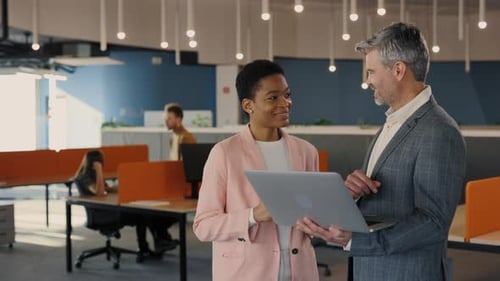 Handsome Office Worker Showing Something to His Female Coworker at the Laptop