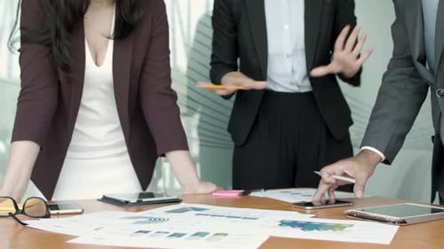 Business Team Discussing Charts at Table